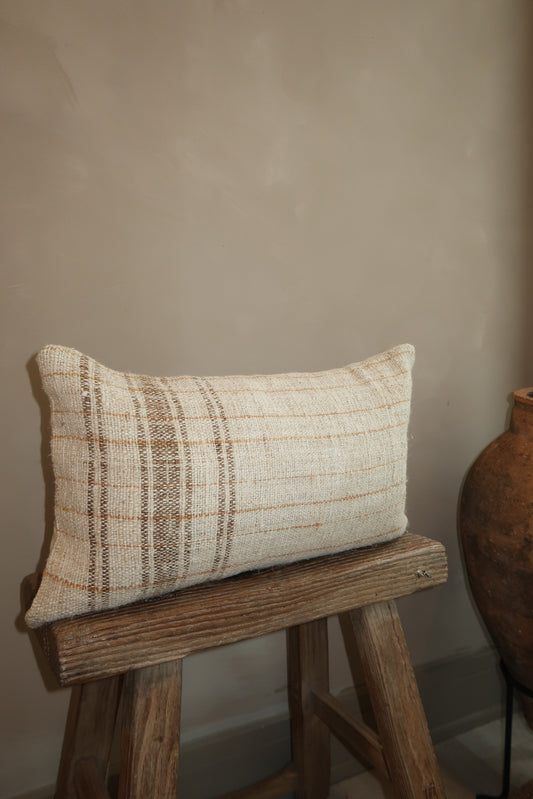 plaid kilim lumbar pillow on a wood stool