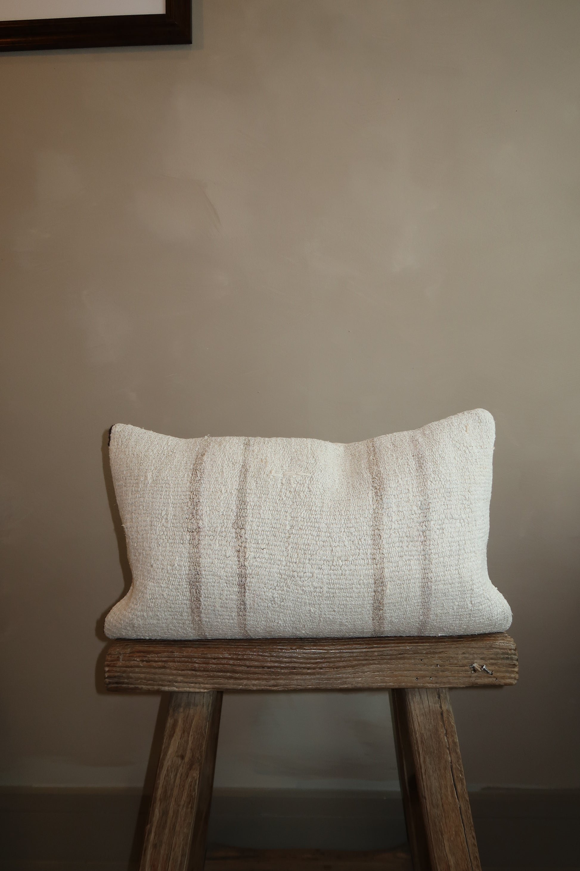 12x20 kilim lumbar pillow with stripes on top of stool