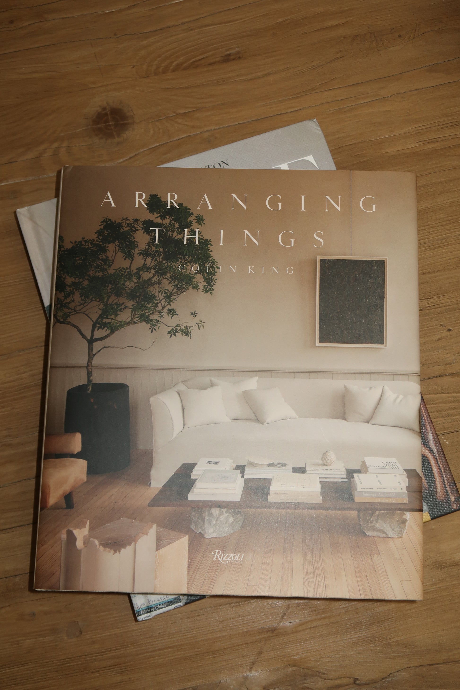 arranging things, coffee table book, interior design book on wood table, book on coffee table
